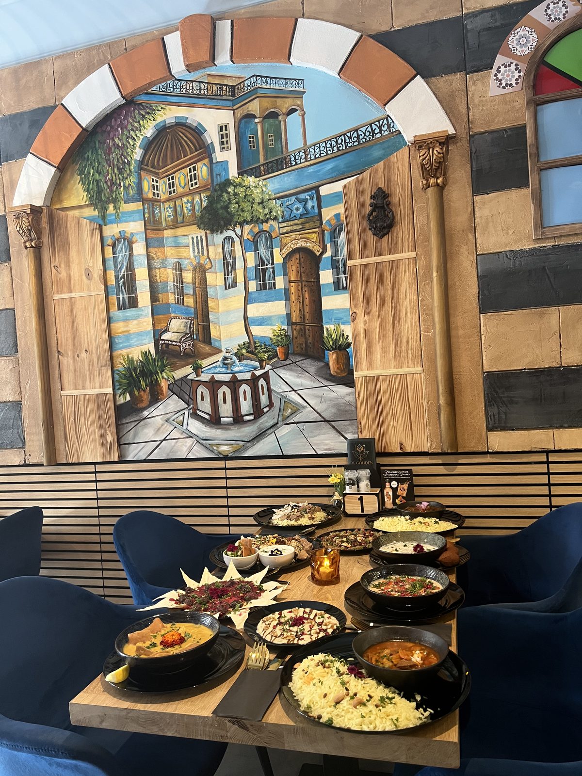Gedekte tafel in de Syrische huiskamer, met de Damascus-muurschildering